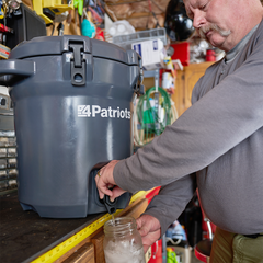 man pouring water from the Patriot Pure Outdoor Filtration System