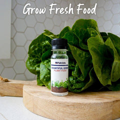 Bottle of 4Patriots bountiful green plant food on a cutting board next to some lettuce. Grow fresh food.