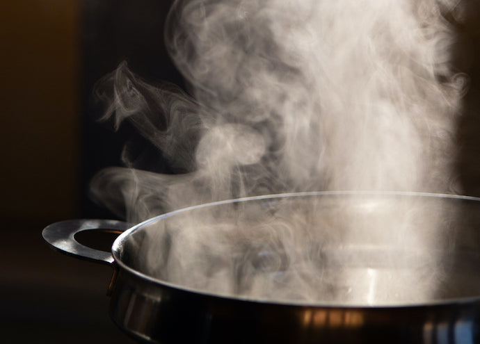 Boiling water in pan. Cooking pot on stove with water and steam