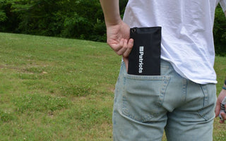 A person slipping a slim 4Patriots pocket tool into their jeans pocket outdoors
