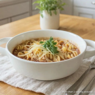A delicious bowl of sausage pasta marinara on a dining room table. 