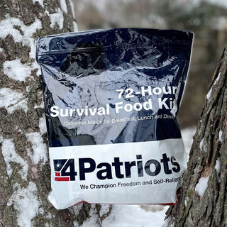 72-Hour Emergency Survival Food Kit freeze-dried survival food pouch resting against a snow-covered tree trunk outdoors in winter