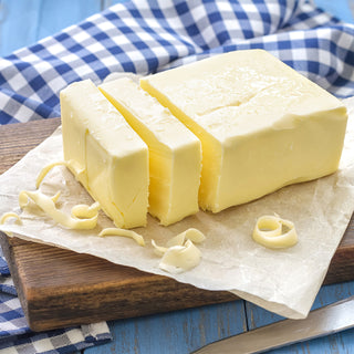 4Patriots Butter Powder #10 Can represented by a sliced block of creamy butter on parchment with a knife and checkered cloth, survival food serving idea