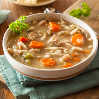 Bowl of chicken noodle soup with carrots, celery and shredded chicken garnished with parsley, made from the Ultimate Chicken Meat Jumbo Can.