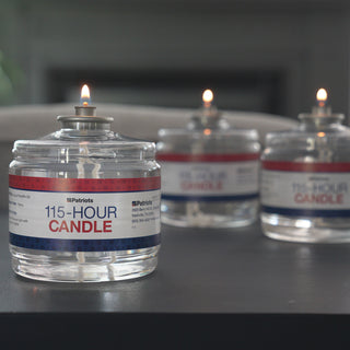 Three lit 4Patriots 115-Hour Candles in clear jars with red and blue labels, sitting on a dark table in a living room