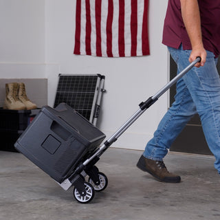 Man walks the Roll & Go Foldable Generator Cart across a garage with a Patriot Power Generator tilted back on its swivel wheels, no heavy lifting
