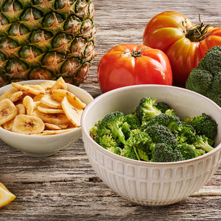 Fruit, Veggie & Snack kit foods from the Family Favorites Emergency Survival Food Package — freeze-dried broccoli and banana chips beside fresh produce.