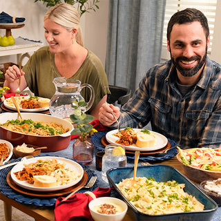 Smiling couple shares a dinner of pasta and sloppy joes prepared from the Family Favorites Emergency Survival Food Package at home.