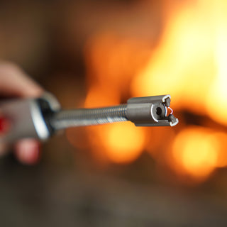Close-up of the 4Patriots Freedom Flame Rechargeable Flexible Arc Lighter tip showing its electric plasma arc against a warm fire glow