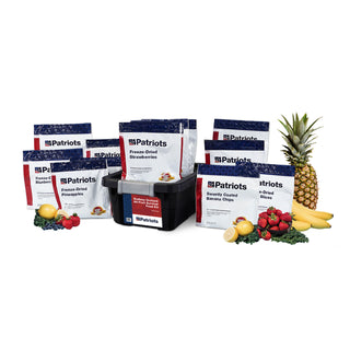 Endless Orchard All-Fruit Survival Food Kit pouches and storage bin surrounded by fresh strawberries, blueberries, pineapple, and bananas