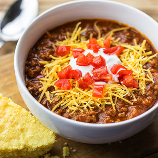 Gluten-Free Variety Recipes #10 Can prepared as a bowl of chili topped with cheese and sour cream beside cornbread, survival food meal.
