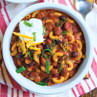 Ma's Hearty Cheesy Chili Mac Pouch prepared as chili macaroni topped with sour cream, cheddar and green onions, hearty survival meals