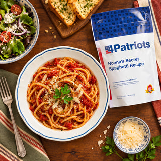 Nonna's Secret Recipe Spaghetti Pouch overhead with spaghetti in red sauce, shaved parmesan, garlic toast and a green salad, comforting survival meals