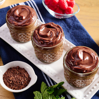 Old-Fashioned Chocolate Pudding Pouch prepared as three mason jars of chocolate pudding with raspberries and mint, survival food dessert