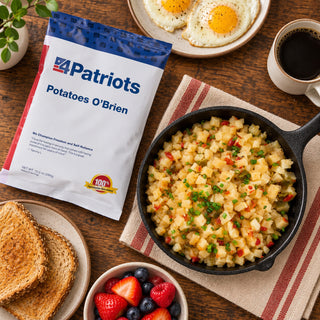 Potatoes O'Brien Pouch flatlay with a skillet of diced potatoes and chives, fried eggs, wheat toast, berries and black coffee, emergency food breakfast