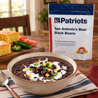 San Antonio's Best Black Beans Pouch behind a bowl of black bean soup with sour cream, corn and peppers beside cornbread and jalapenos, emergency food