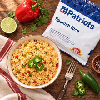 Spanish Rice Pouch overhead with a bowl of seasoned rice topped with sliced jalapeno, a red bell pepper, lime and cilantro, emergency food supply