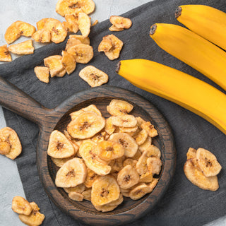 Sweetly-Coated Banana Chips Pouch lifestyle photo of a white bowl of banana chips beside the 4Patriots pouch on a cutting board, grab-and-go survival food