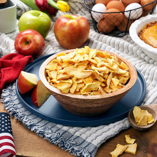 Wooden bowl of 4Patriots Freeze-Dried Apple Slices with fresh apples and eggs on a table, a survival food snack and emergency food