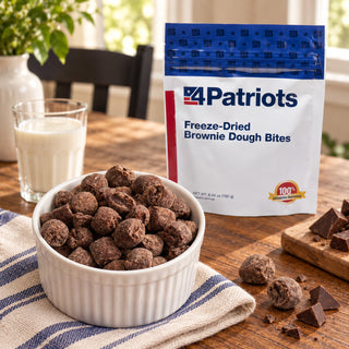Freeze-Dried Brownie Bites Pouch behind a ramekin of cocoa-dusted brownie dough bites with a glass of milk and chopped chocolate, a sweet survival food treat