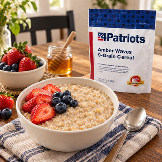 Amber Waves 9-Grain Cereal Pouch behind a warm bowl of hot cereal with strawberries and blueberries, a honey jar and spoon on a kitchen table, survival food