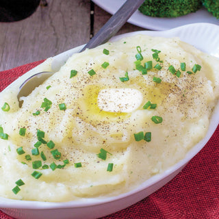Creamy Herbed Mashed Potatoes Pouch prepared in a white dish topped with butter, chives and cracked pepper, comforting emergency food side dish