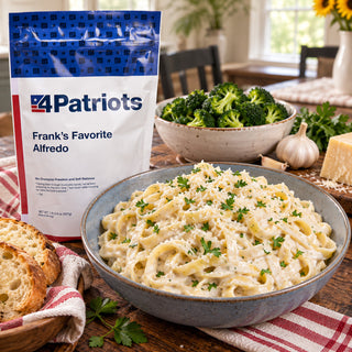 Frank's Favorite Alfredo Pouch beside a stoneware bowl of fettuccine alfredo with parmesan and parsley, broccoli, garlic and sliced bread on red check cloth, survival meals