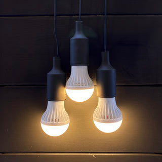 3-Strand LED Light String with three bulbs glowing warm light while hanging against a dark wall, portable emergency lighting for power outages