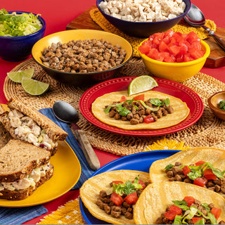 Gold Medallion All-Meat Emergency Survival Kit prepared-table spread of freeze-dried beef tacos, chicken salad sandwich and bowls of rehydrated beef and chicken for long-term food storage
