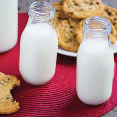 Two glass bottles of milk on a table