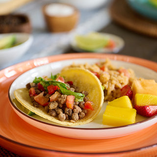 Plated beef tacos with seasoned rice and fresh fruit made from the Meat & Protein Deluxe Emergency Survival Food Kit, an easy survival meal