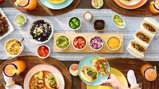 Meat & Protein Deluxe Emergency Survival Food Kit in a taco-night flatlay of ground meat tacos, black beans, rice, guacamole, salsa and toppings, long-term food storage for disaster preparedness