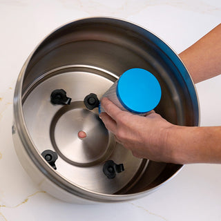 Hands seating a Patriot Pure Nanomesh Filter into the base of the stainless housing, showing correct filter stopper placement for water purification