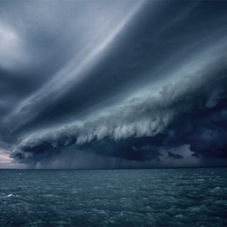 Massive shelf cloud from an approaching hurricane rolling in over dark open water, the kind of severe storm emergency preparedness plans are built for
