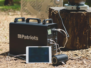 Patriot Power Solar Generator 1800 powering multiple devices at camp, running a tablet, speaker, fan and hot plate for off-grid emergency backup power