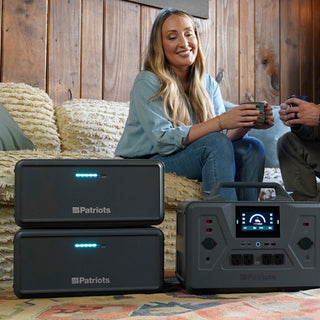 Expansion Battery Pack for Patriot Power Generator 2200X, square crop of two stacked packs and the 2200X in a cozy living room with a couple enjoying off-grid backup power