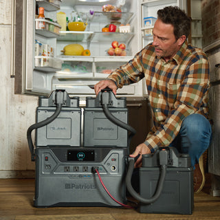 Man connecting two Expansion Battery Packs to a Patriot Power Generator 2500X to power a full refrigerator
