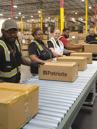Patriot Power Generator 1800 + Sidekick Kit undergoing warehouse quality check as workers inspect 4Patriots boxes of portable solar generators for off-grid emergency backup power