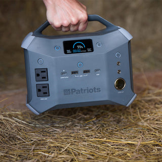 Patriot Power Generator 1800 + Sidekick Kit: hand lifts the Sidekick portable power station by its handle in a barn, grab-and-go off-grid emergency backup power