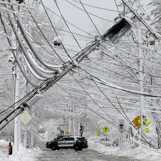 Patriot Power Voyager XL Solar Power Bank for winter storm emergencies — a home in heavy snow shows why a portable off-grid solar charger matters when winter downs the grid