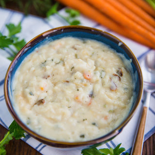 Soups & Stews Variety #10 Can shown as a bowl of creamy chicken-flavored campfire soup with rice and carrots, survival food