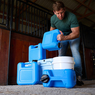 Silver Star Emergency Survival Package: man pouring from a blue stackable water container into a bucket beside three more stacked in a stable, emergency water storage