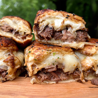 Stacked cheesy beef sliders made with Ultimate Meat Medley canned beef, griddled and served on a wooden board