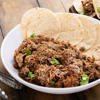 Bowl of shredded pork from the Ultimate Meat Medley with warm tortillas and cilantro, taco night from a canned survival meal