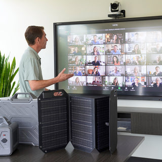 Seth Weller leading a 4Patriots online class, presenting to a large group video call on screen with a Patriot solar generator and folding solar panel in the foreground