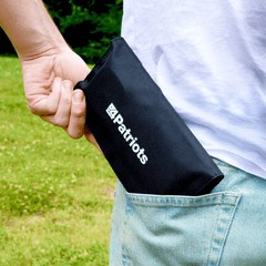 PocketSun solar panel folded up and being put inside a persons back pocket