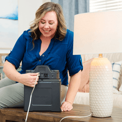 Woman powering lamp by plugging it into the Patriot Power Generator 2000X Expansion Pack