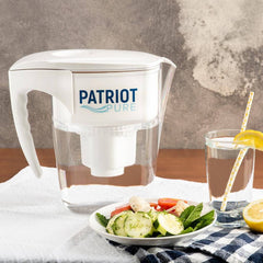 Patriot pure pitcher on a table next to a glass of water and plate of food.