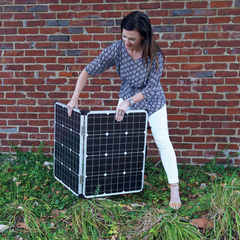 Woman unfolding the Patriot Power Generator 100-Watt Folding Solar Panel