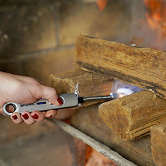 Someone using the Freedom flame to light a fireplace